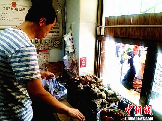 圖為凌君道正在將粽子裝袋進行售賣?！「呖档?攝